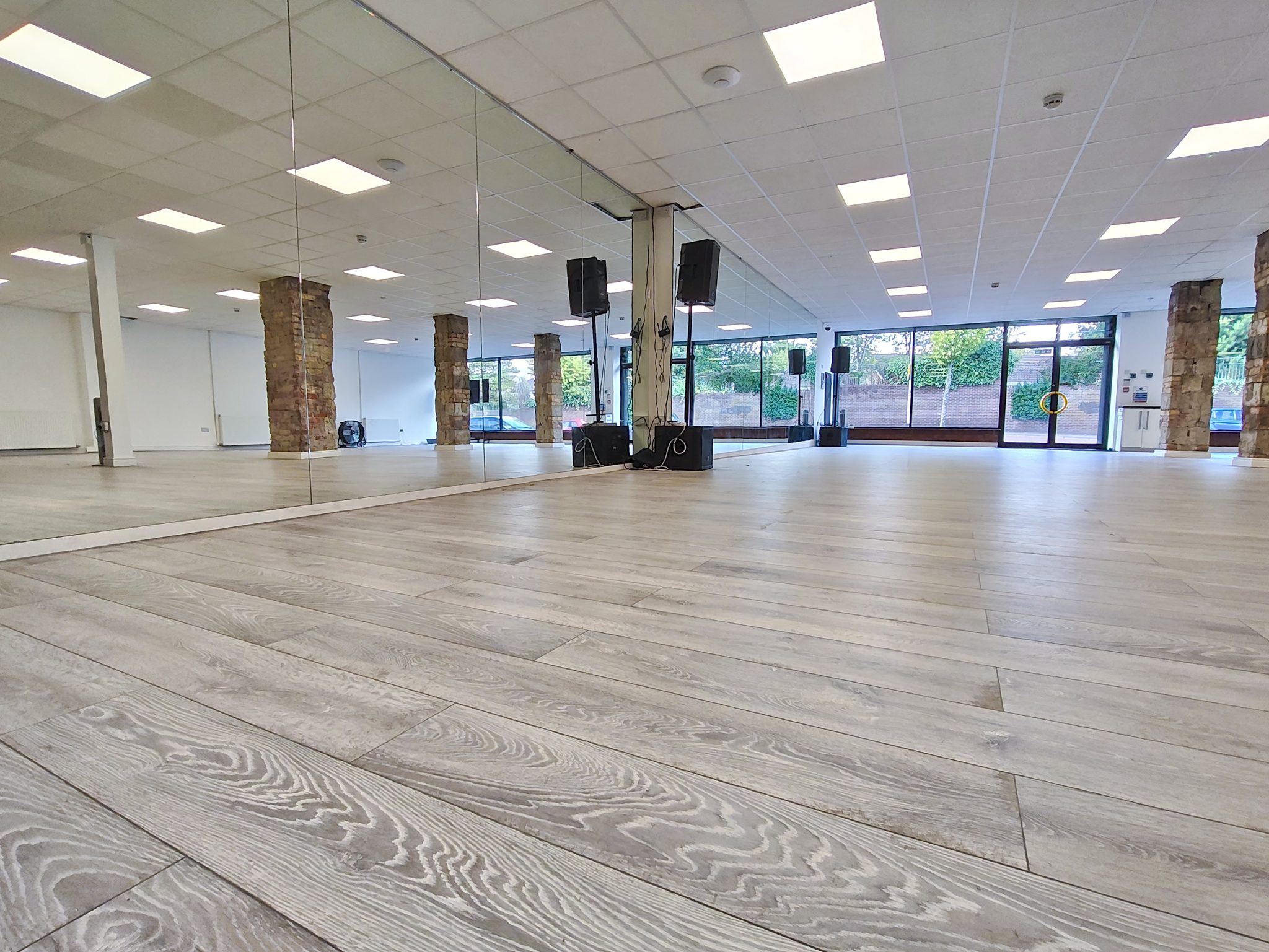 The finished Peters Hill hall: mirrored wall, PA speakers on stands and the glass shopfront at the far end.