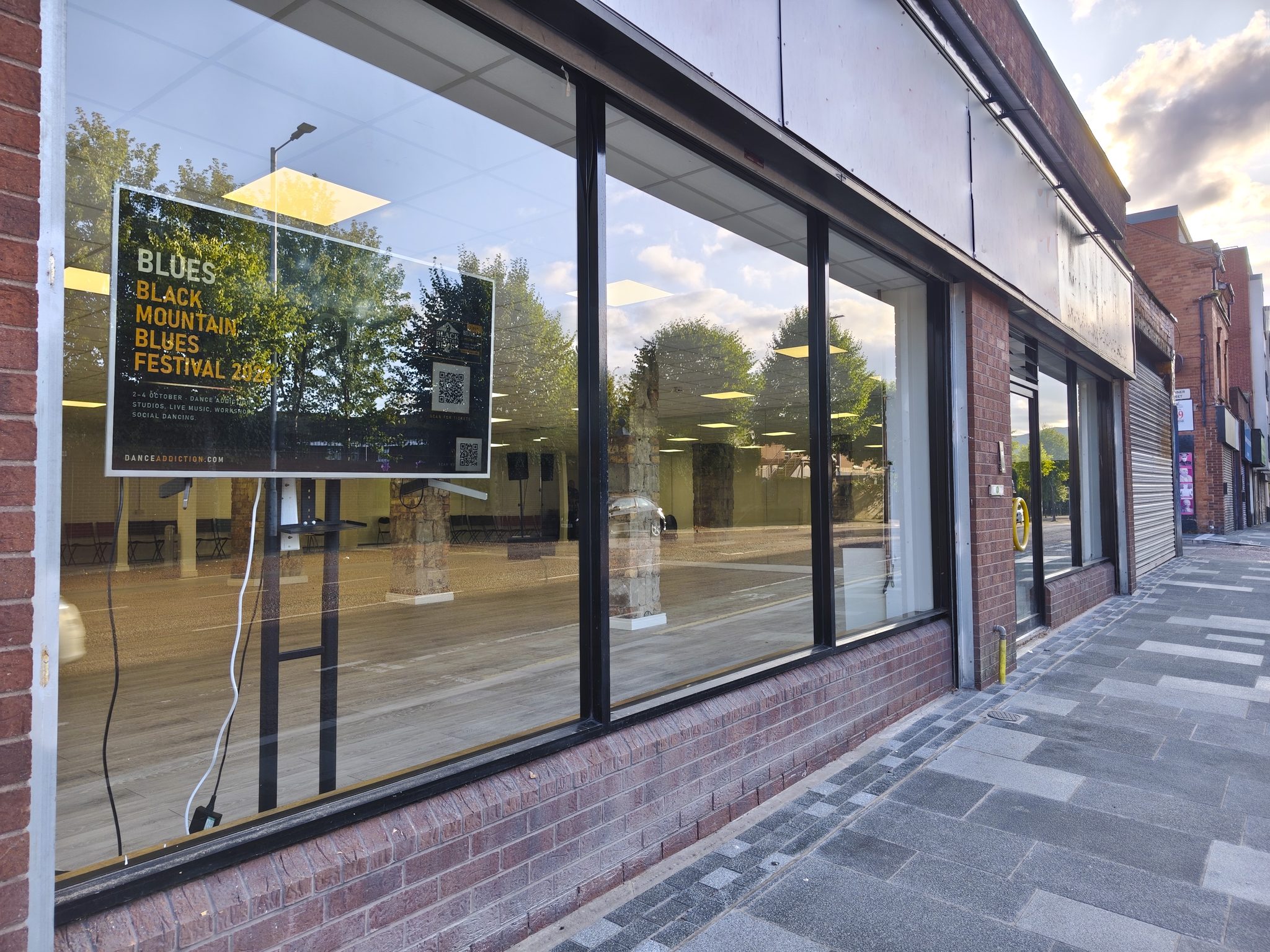 The front of 30–32 Peters Hill: a long run of full-height glass shopfront windows in a red-brick building, the studio floor visible inside.